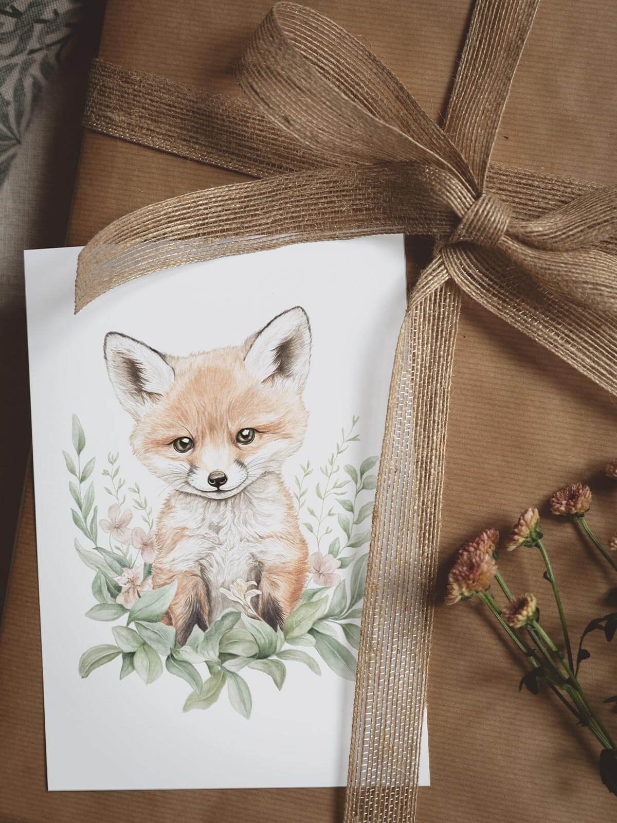 A5 akvarellkort med räven Remi på paket med juteband och blomma