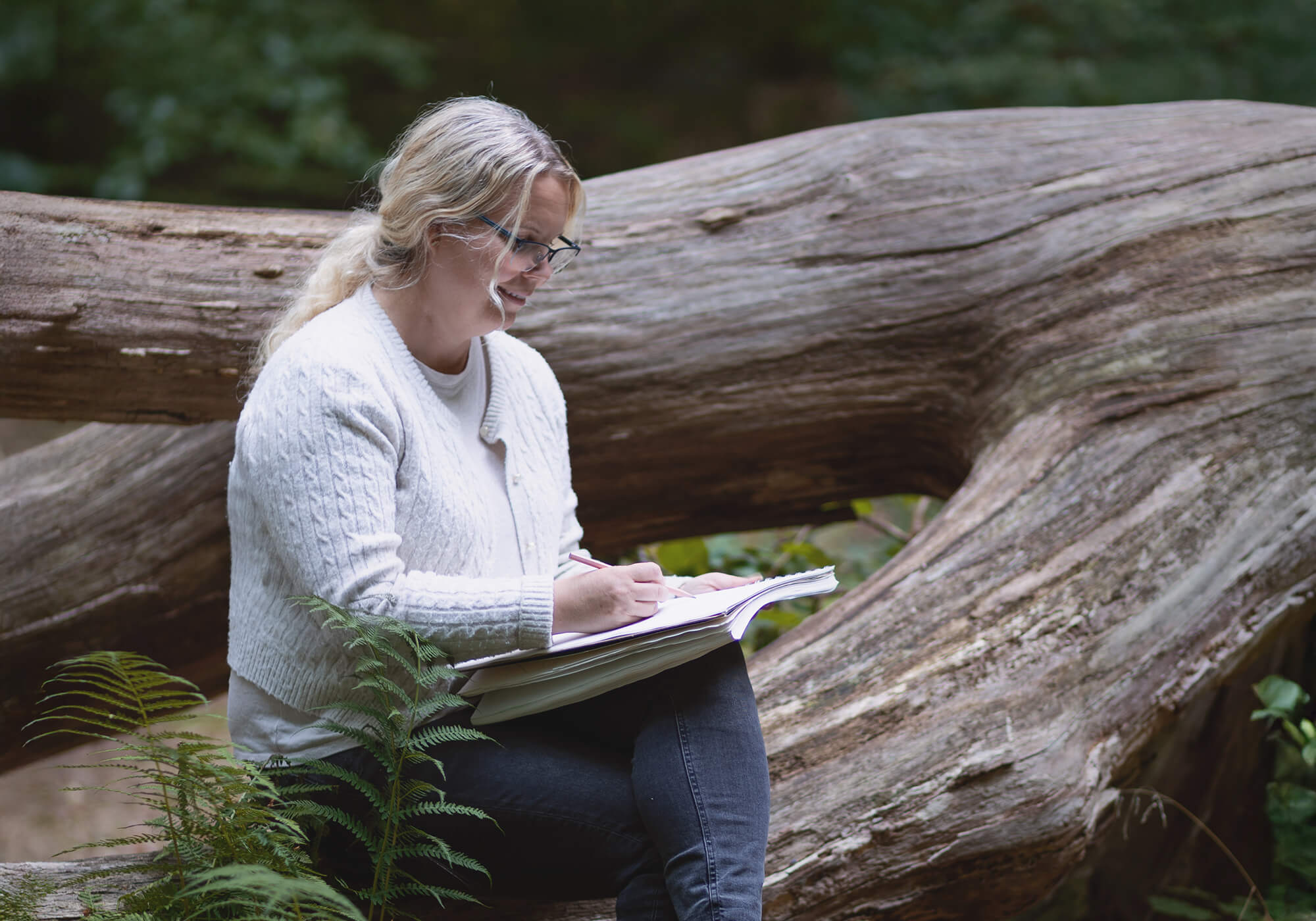 Illustrator Karolina Brunström painting with watercolors in the forest