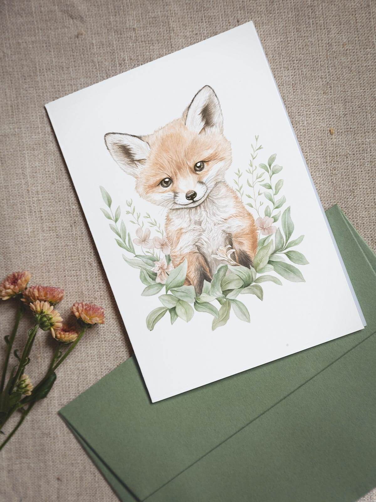 Akvarellkort A6 med räven Remi och grönt kuvert på linneduk med blomma