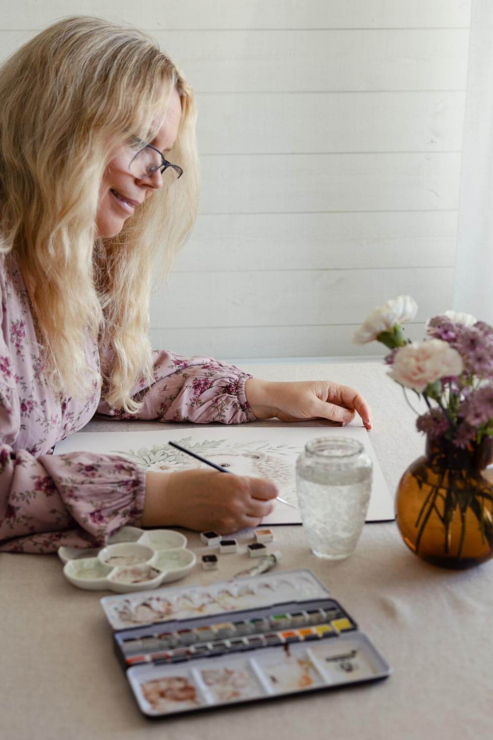 Karolina Brunström painting with watercolors at her work desk