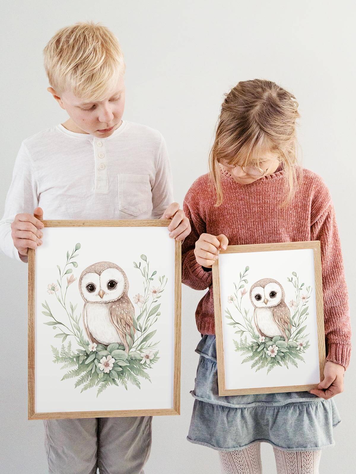 Barn håller handmålad poster med ugglan Nova i ekram